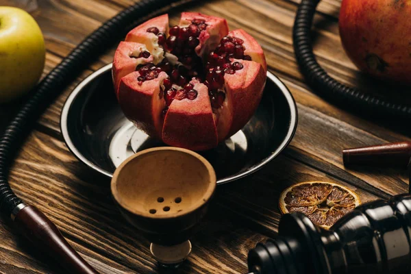 Hookah, garnets, apple and dried cut oranges on wooden surface — Stock Photo