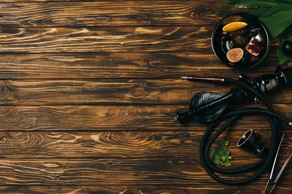 Top view of hookah and exotic fruits on wooden surface — Stock Photo