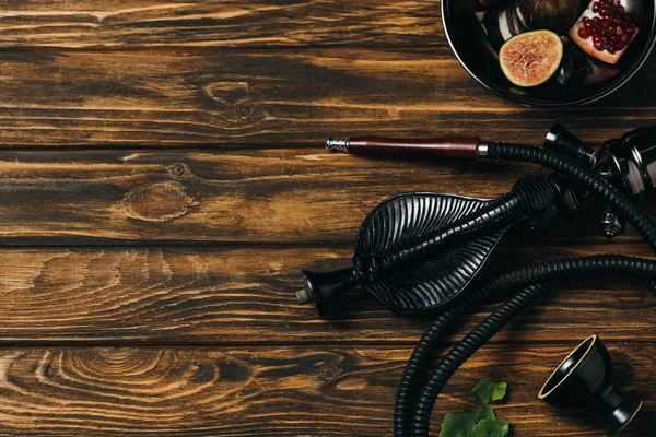 Top view of hookah and exotic fruits on wooden surface — Stock Photo