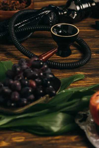 Foco seletivo de uvas e narguilé na superfície de madeira — Fotografia de Stock