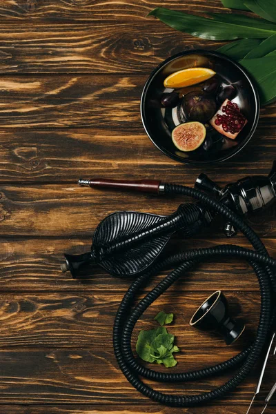 Top view of hookah and exotic fruits on wooden surface — Stock Photo