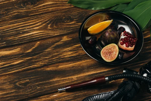 Fruits frais savoureux et narguilé sur la surface en bois — Photo de stock