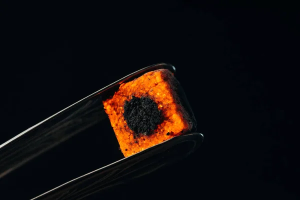 Hookah tongs and hot coal isolated on black — Stock Photo