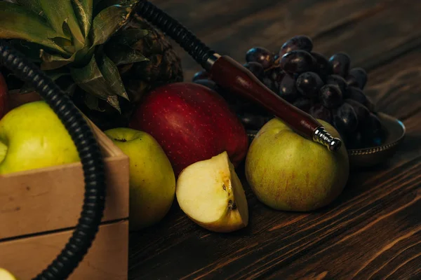 Manzanas, uvas, piña y narguile en la superficie de madera - foto de stock