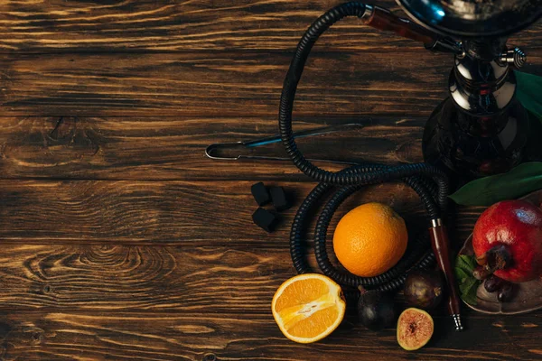 Vue de dessus des fruits frais, charbons et narguilé sur la surface en bois — Photo de stock