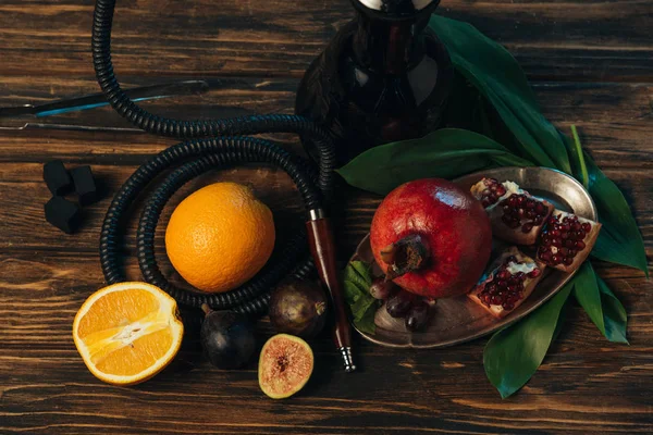 Top view of fresh fruits, coals and hookah on wooden surface — Stock Photo