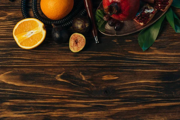 Vista dall'alto di frutta esotica fresca e narghilè sulla superficie di legno — Foto stock