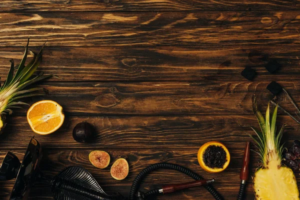 Vista dall'alto di frutta fresca, carboni e narghilè sulla superficie di legno — Foto stock