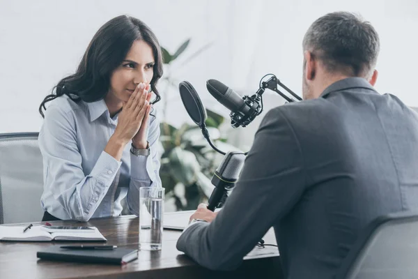 Attentive radio host itterviewing businessman in broadcasting studio — Stock Photo