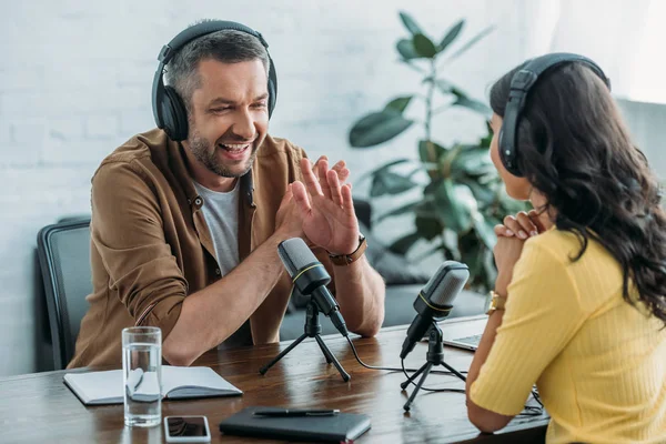 Allegro conduttore radio che non mostra alcun segno durante la registrazione di podcast con il collega — Foto stock