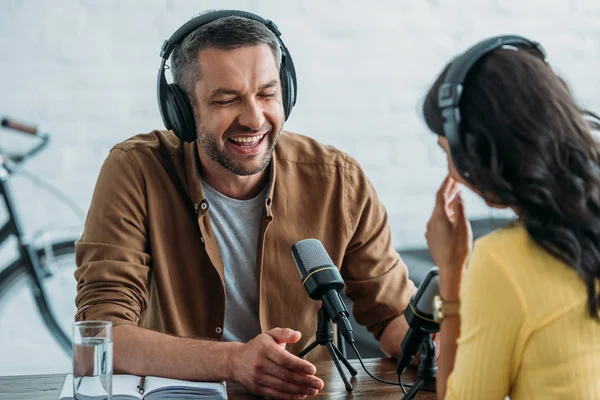 Cheerful radio host laughing while recording podcast with colleague — Stock Photo