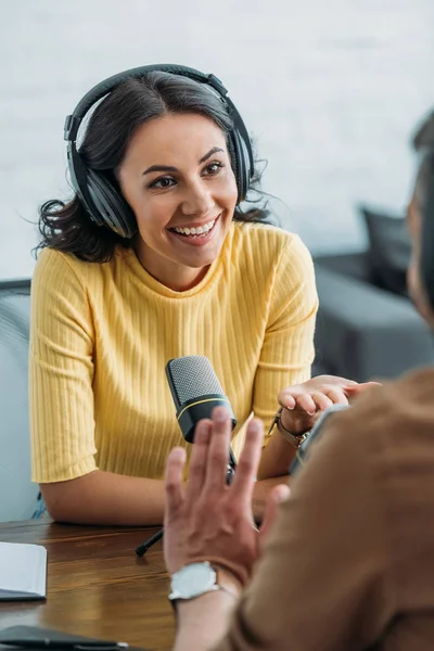 Attrayant animateur de radio souriant tout en parlant à un collègue dans un studio de radiodiffusion — Photo de stock