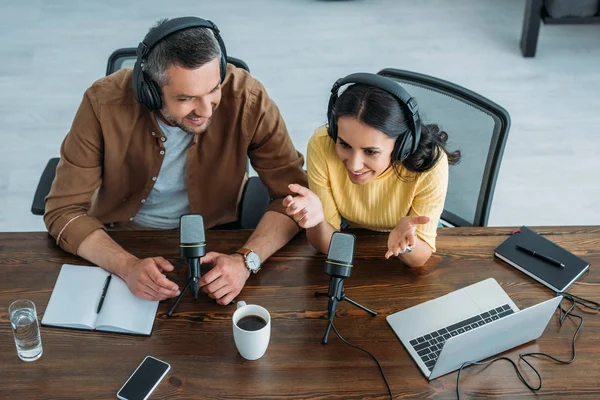 Blick von oben auf zwei lächelnde Radiomoderatoren bei der Aufzeichnung eines Podcasts im Radiostudio — Stockfoto