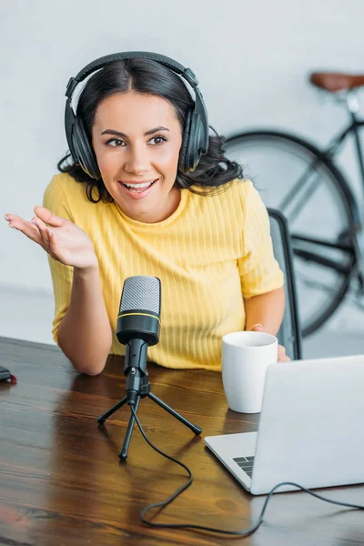 Alegre rádio anfitrião gesto enquanto fala em microfone em estúdio — Fotografia de Stock