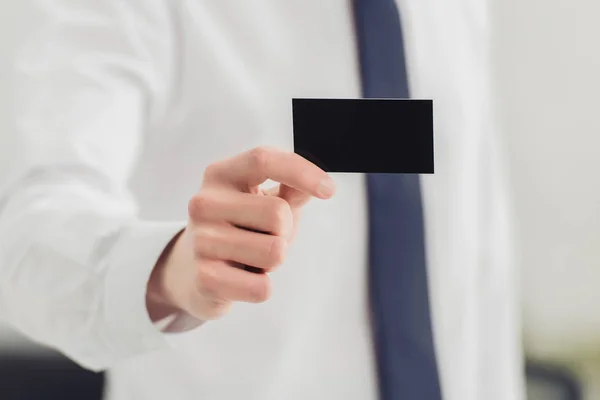 Vue recadrée de l'homme d'affaires montrant à la caméra noir carte de visite vide — Photo de stock