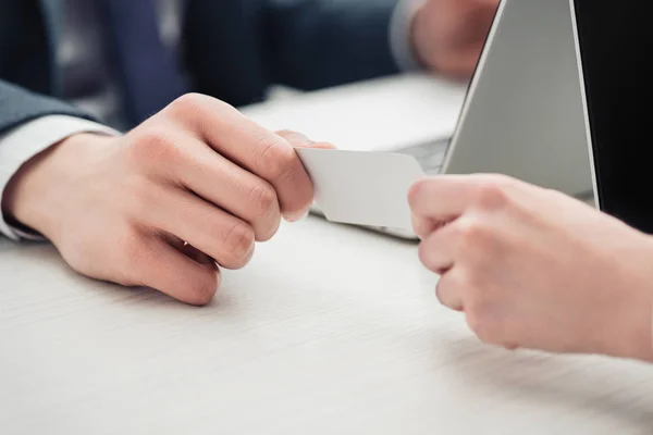 Partial view of businessman and businesswoman holding empty business card — Stock Photo