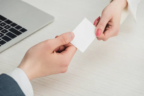 Cropped view of businessman and businesswoman holding white empty business card, panoramic shot — Stock Photo