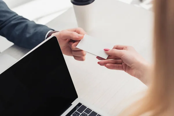 Cropped view of businesspeople holding white empty business card in office — Stock Photo