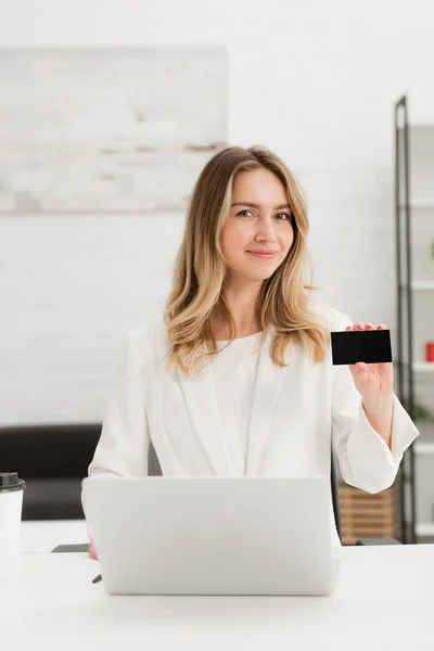 Cheerful businesswoman showing at camera black empty business card — Stock Photo