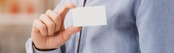 Vista cortada de empresário segurando branco vazio cartão de visita, tiro panorâmico — Fotografia de Stock