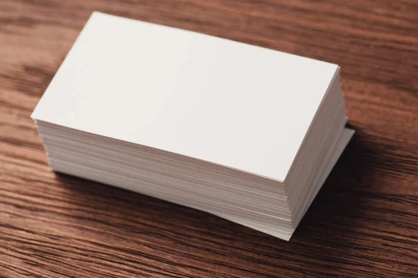 Stack of white blank business cards on brown wooden surface — Stock Photo