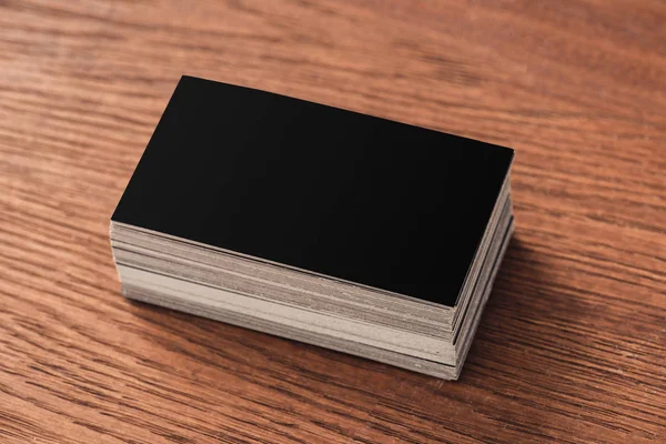 Stapel schwarzer leerer Visitenkarten auf braunem Holztisch — Stockfoto