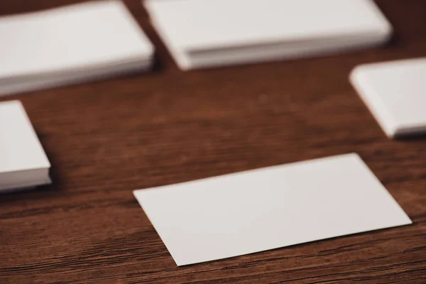 Selective focus of white blank business cards on brown wooden surface — Stock Photo