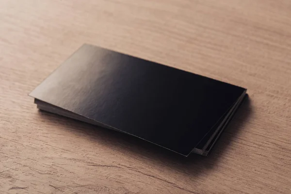 Stapel leerer schwarzer Visitenkarten auf strukturierter Holzoberfläche — Stockfoto