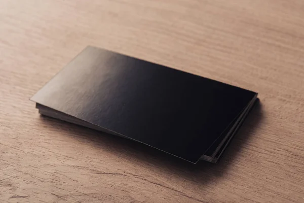 Stack of black empty business cards on textured wooden surface — Stock Photo