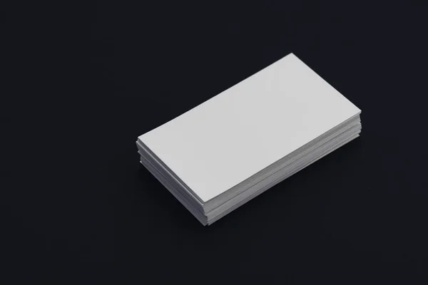 Stack of blank white business cards on black background — Stock Photo