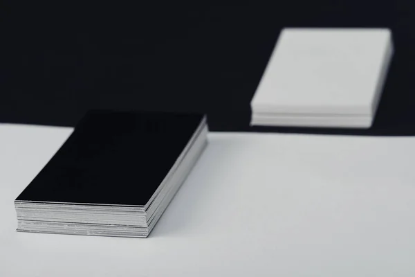 Stacks of empty business cards on black and white background — Stock Photo