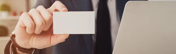 Cropped view of businessman presenting blank business card at camera, panoramic shot — Stock Photo