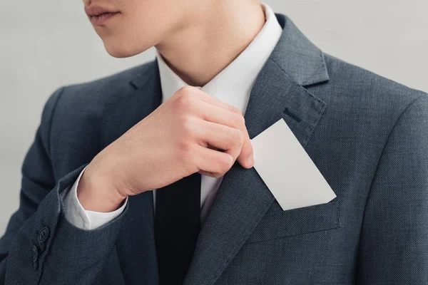 Recortado disparo de hombre de negocios en traje con tarjeta de visita en blanco - foto de stock