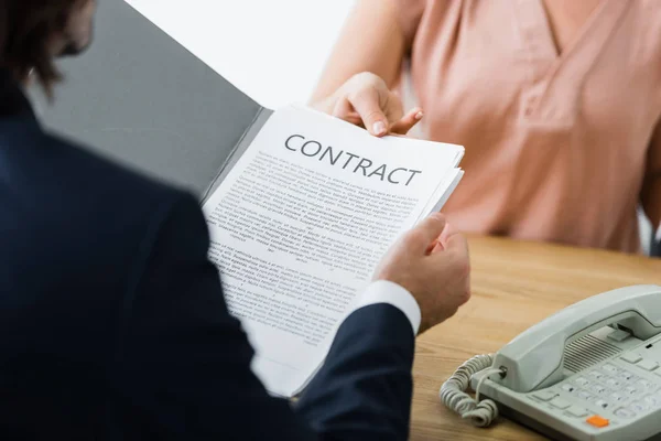 Cropped view of woman and businessman holding contract in hands — Stock Photo