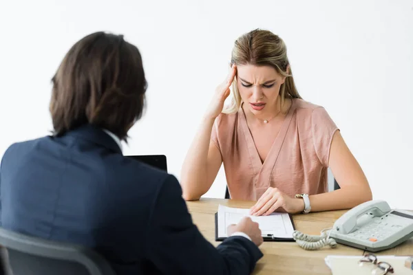 Worried woman sitting in office, talking with businessman and looking at contract — Stock Photo