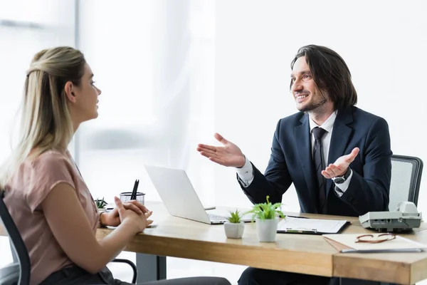 Selektiver Fokus des fröhlichen Geschäftsmannes im Gespräch mit dem Mandanten im Büro — Stockfoto