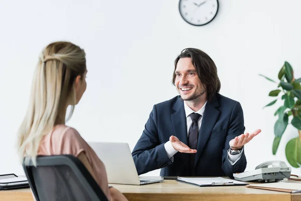 Selektiver Fokus des fröhlichen Geschäftsmannes im Gespräch mit dem Mandanten im Büro — Stockfoto