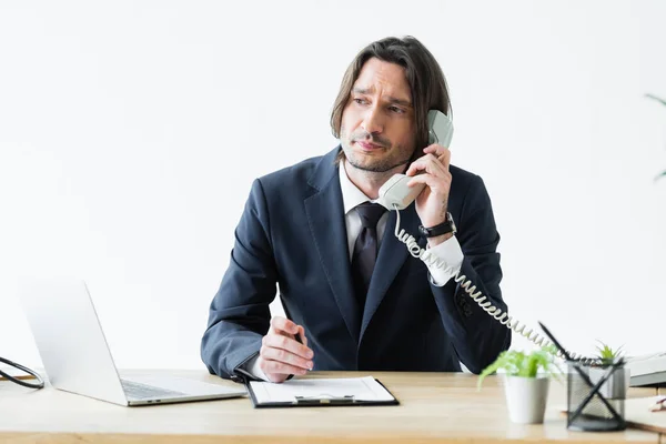 Sad businessman talking on phone and looking away — Stock Photo