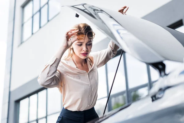 Businesswoman looking at open auto trunk, car insurance concept — Stock Photo