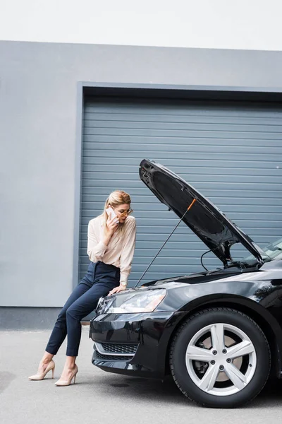 Businesswoman talking on smartphone while standing near broken auto, car insurance concept — Stock Photo