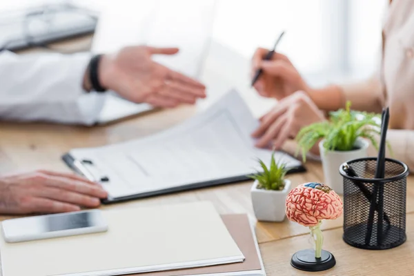 Cropped view of doctor with patient signing insurance claim form — Stock Photo