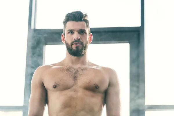 Guapo barbudo sin camisa hombre en el gimnasio con humo - foto de stock