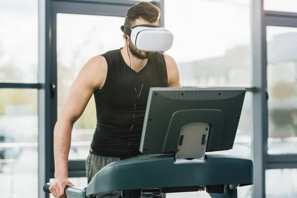 Sportsman in virtual reality headset running on treadmill at sports center — Stock Photo