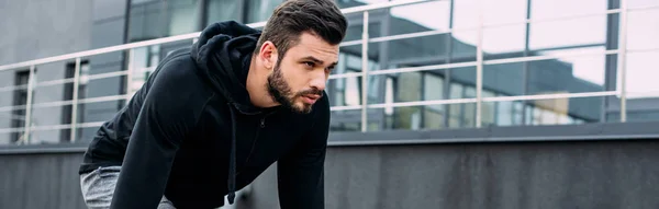 Tiro panorâmico de belo desportista na posição inicial pronto para correr — Fotografia de Stock