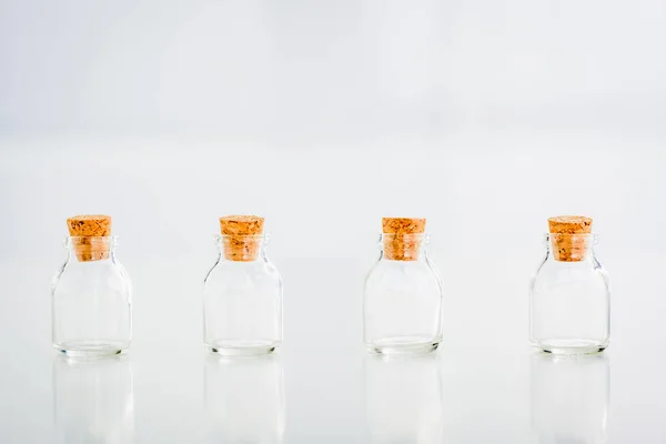 Empty corked glass jars on white background with copy space — Stock Photo