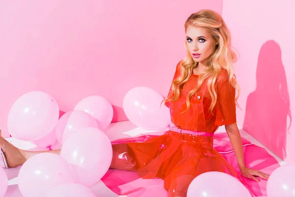 Belle fille posant près de ballons sur rose, concept de poupée — Photo de stock