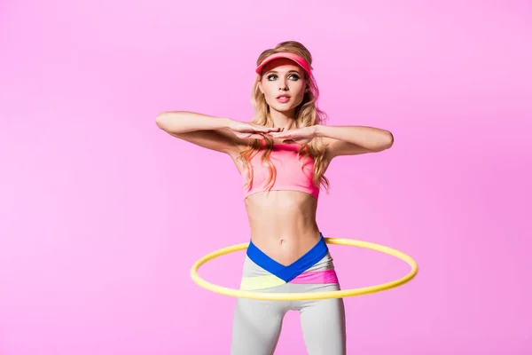 Красивая девушка в спортивной форме тренировки с обручем изолированы на розовый, кукла концепции — стоковое фото