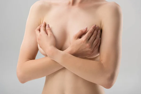 Partial view of sexy naked girl covering breast isolated on grey — Stock Photo