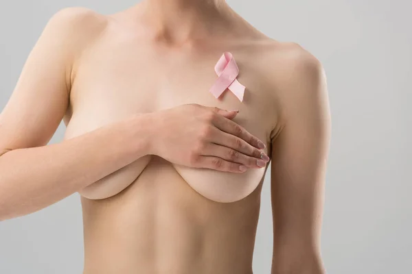 Cropped view of naked young woman with pink ribbon isolated on grey — Stock Photo