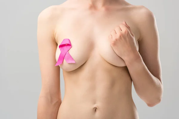 Cropped view of naked young woman with pink ribbon isolated on grey — Stock Photo